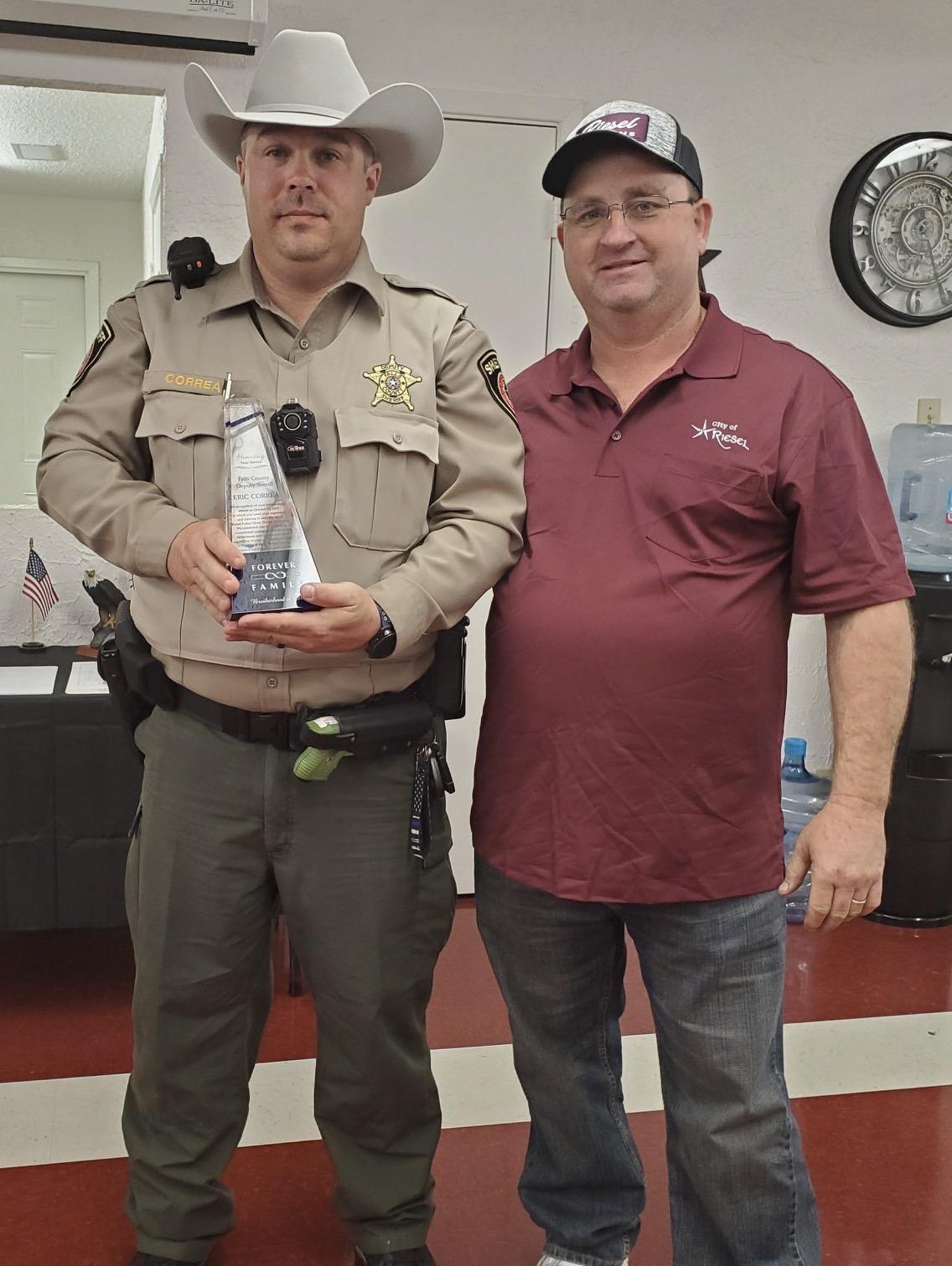 Deputy Eric Correa accepted an award from Reisel Mayor Kevin Hogg.